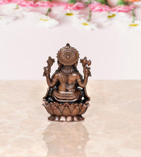 Copper Ganpati idol statue, back view with halo-like headpiece, seated on lotus base