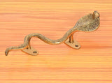 Two-piece brass snake door handle with golden plates on wooden door