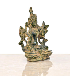 Brass Tara Devi statue, angled view: seated deity with multi-armed floral motifs