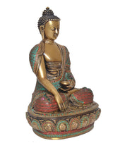 Brass meditating Buddha idol, angled side view; golden face and colorful beaded sash