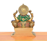 Back view of brass Ganesha statue with circular halo and multicolor green-and-red attire