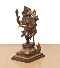 Brass dancing Ganesha statue from side view, ornate crown and hand-held staff