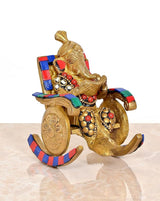 Brass Ganesha statue on chair, reading, colorful chair panels and detailed ornaments