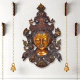 Tara wall hanging mask statue with gold face, ornate bronze detailing, hanging chains
