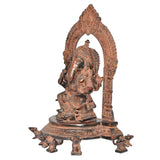 Brass Ganesh seated sculpture shown from side, Abhaya mudra, ornate arched backrest