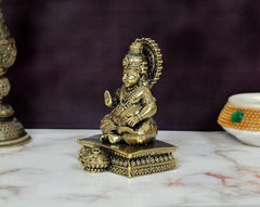 Kuber Bhagwan bronze murti, side view of seated deity on patterned base