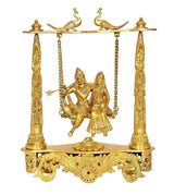 Brass Radha-Krishna swing statue with detailed columns, hanging chains, and peacocks