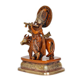 Brass Lord Krishna figurine with cow, side angle on decorated base