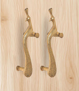 Brass peacock door handle pair viewed from side, showing pins and curved grip shape