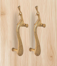 Brass peacock door handle pair viewed from side, showing pins and curved grip shape