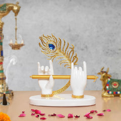White resin Krishna hands holding gold flute, blue peacock design on round base