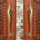 Brass door handle pair with dolphin and fish design, golden finish on door