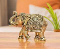 Bronze elephant figurine, raised trunk with ornate etched patterns on body and legs