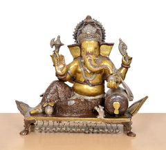 Brass Ganesha idol seated on pedestal with raised hands and detailed ornaments