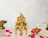 Golden brass Ganesha statue: seated on chair, reading book, 5 inch height