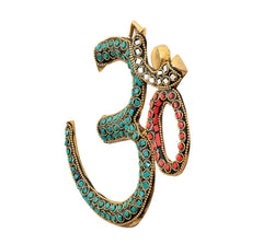 Brass OM wall hanging sculpture angled view with teal gems and red oval accents