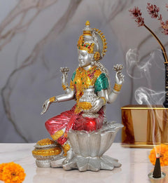 Lakshmi resin statue seated on lotus, red sari and teal top, holding pot