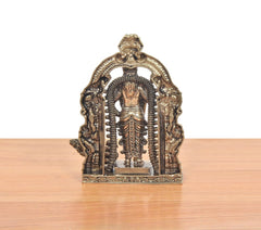 Bronze standing Murugan idol viewed from front through arched prabhavali, ornate base