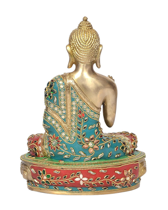 Seated brass Buddha idol from rear view, gold head and torso, turquoise and red patterned base