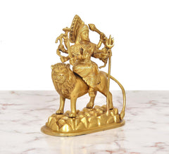 Durga Maa brass statue riding lion with trident and raised arms, golden finish
