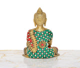 Back view of brass Buddha statue, multicolor jeweled robe and seated posture