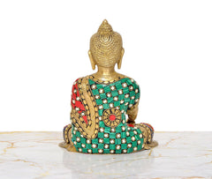 Back view of brass Buddha statue, multicolor jeweled robe and seated posture