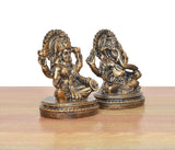 Lakshmi and Ganesh resin figurines from a three-quarter angle, ornate gold detailing