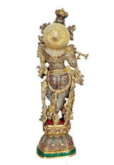 Brass Krishna statue back view with arched headpiece, textured gold and colorful patterns