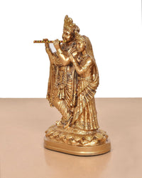 Golden Radha Krishna idol, side view with flute held near mouth and ornate dress