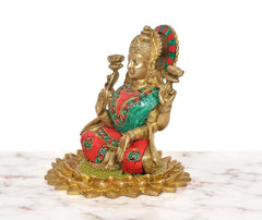 Brass Lakshmi idol side view, seated on lotus base with raised hands and jeweled belt