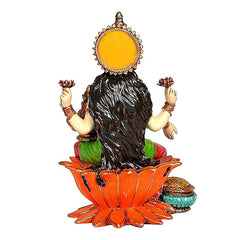 Back view of Lakshmi statue with gold halo, long dark hair, orange lotus base