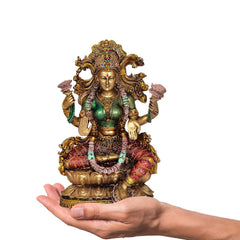 Lakshmi resin idol in hand for scale, seated goddess with gold crown, green dress, red skirt