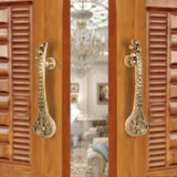 Brass sitar-shaped door handle pair with round knobs and carved detailing