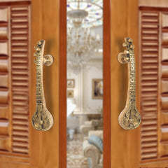 Brass sitar-shaped door handle pair with round knobs and carved detailing