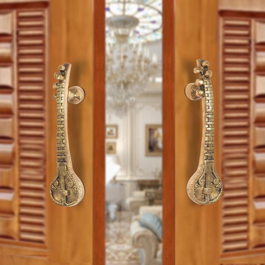Brass sitar-shaped door handle pair with round knobs and carved detailing