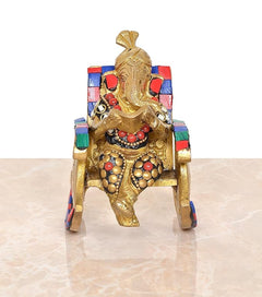 Brass Ganesha statue seated on chair, reading pose, multicolor backrest panels