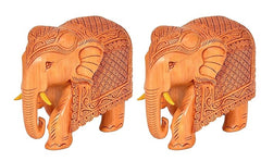 Two tan wooden elephant statues, carved patterns, side view, trunks raised