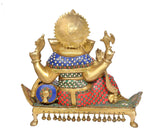 Rear view brass Ganesha idol showing decorated back, blue-and-red cloth, and hanging bells