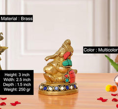 Brass Ganesha statue blowing conch shell with red and green accents, jeweled base