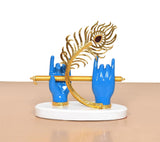 Krishna Deko: goldener Federkranz mit blauem Stein, blaue Hände um die Flöte