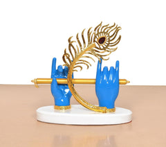 Krishna Deko: goldener Federkranz mit blauem Stein, blaue Hände um die Flöte