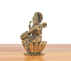 Brass Maa Saraswati idol on lotus, three-quarter view, holding veena.