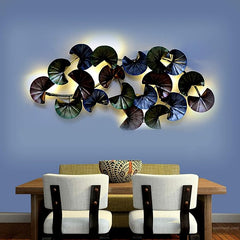 Metal wall sculpture with stacked circular discs in dark green, navy, and silver tones.