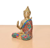 Side view Brass Buddha idol seated, raised hand; multicolor jeweled robe