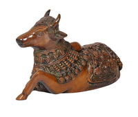Brass Nandi bull statue side view, engraved patterns across torso and saddle