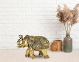 Brass elephant figurine with curled trunk and ornate engravings