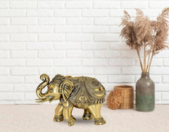 Brass elephant figurine with curled trunk and ornate engravings