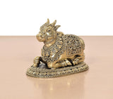 Brass seated Nandi statue viewed from side, intricate jewelry and flowing patterns