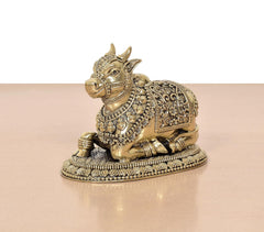 Brass seated Nandi statue viewed from side, intricate jewelry and flowing patterns