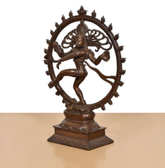 Shiva Nataraj brass idol from side view, ornate circular ring and pedestal